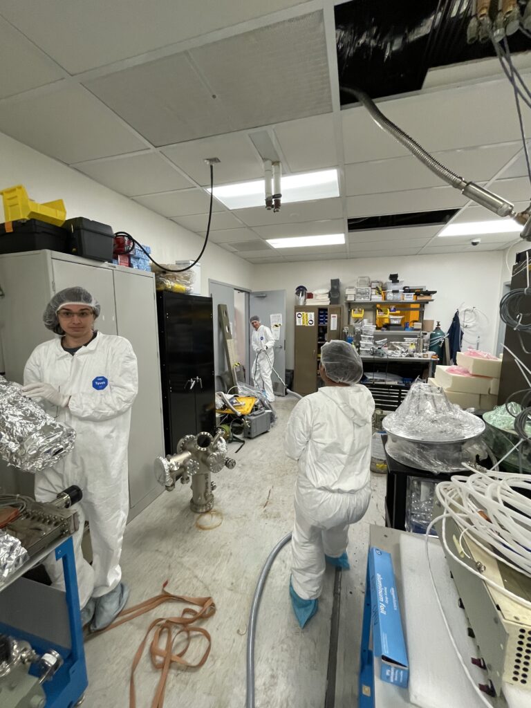 Lab members routing cables through the growth-bay ceiling