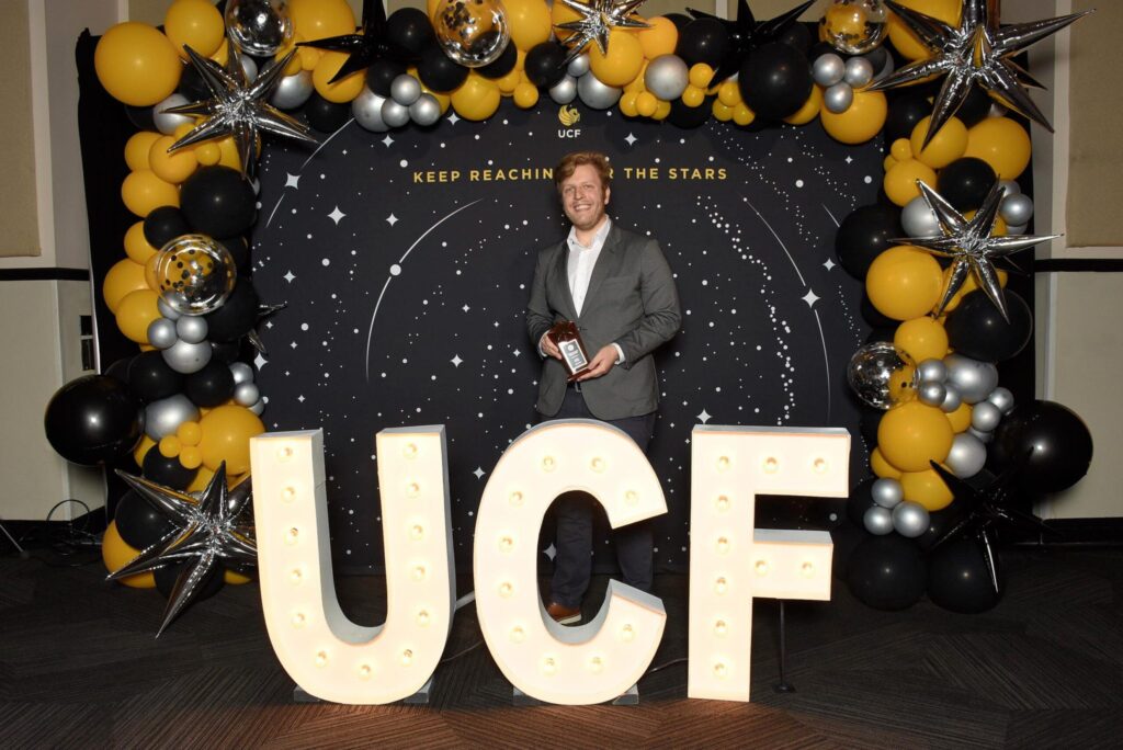 Leland Nordin holding his UCF Reach for the Stars trophy